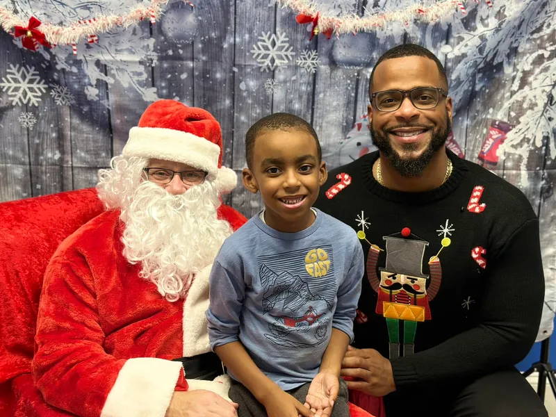 Miguel Jones with his son Machai at a holiday event